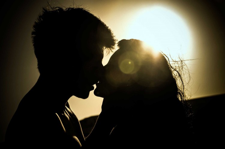 romantic couple kissing at sunset image